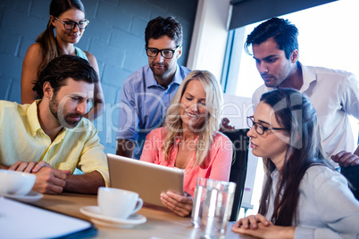 Group of coworkers watching a tablet computer
