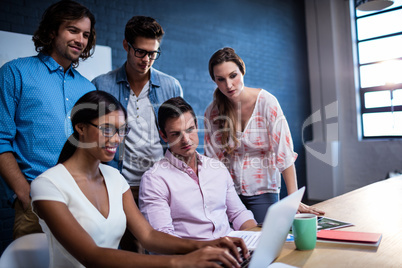 Group of coworkers watching a laptop