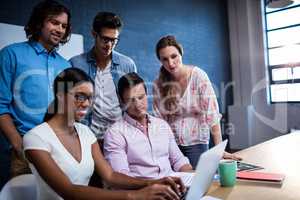 Group of coworkers watching a laptop