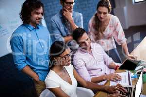 Group of coworkers watching a laptop