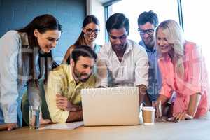 Group of coworkers watching a laptop