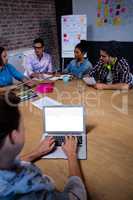 Group of coworkers during meeting and laptop