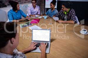 Group of coworkers during meeting and laptop