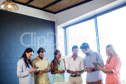 Group of coworkers using laptops and smartphones