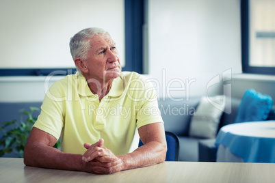 Worried senior man sitting in living room