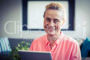 Senior woman holding digital tablet and smiling