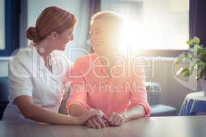 Female nurse consoling senior woman