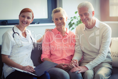 Doctor writing medical report of senior couple