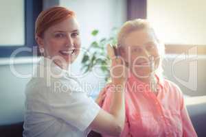 Female nurse combing hair of senior woman