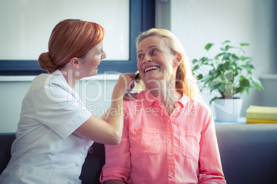 Female nurse combing hair of senior woman