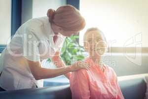 Female nurse consoling senior woman