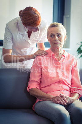 Female nurse consoling senior woman