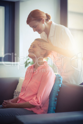 Female nurse giving head massage to woman