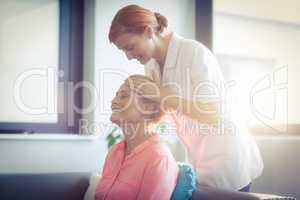 Nurse giving head massage to woman