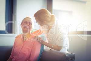 Happy nurse and patient in living room