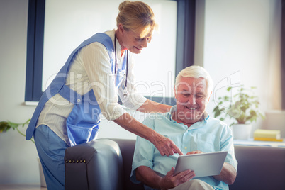 Senior man and female doctor using digital tablet