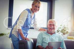 Portrait of senior man and female doctor using digital tablet