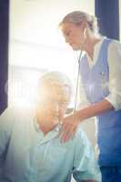 Female doctor examining a senior man