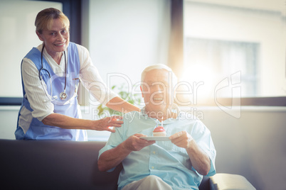 Senior Female doctor celebrating senior mans birthday in hospital