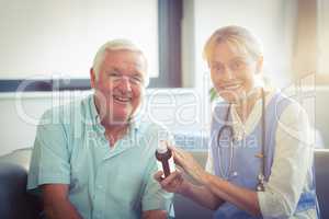 Female doctor giving medicine to senior man