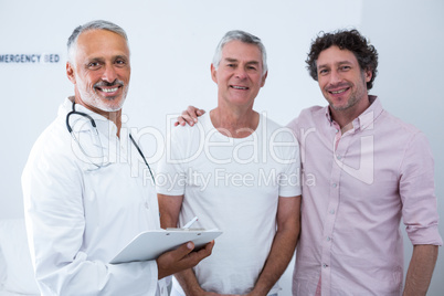 Senior man standing with guardian in hospital