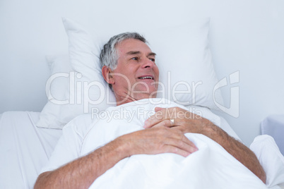 Senior man lying on bed