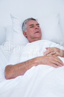 Senior man lying on bed