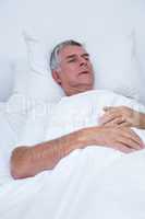 Senior man lying on bed