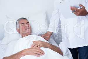 Male doctor examining senior man
