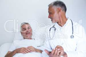 Male doctor and senior man interacting with each other