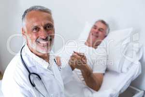 Male doctor consoling senior man