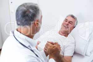 Male doctor consoling senior man
