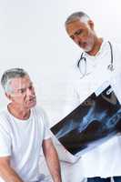 Male doctor discussing x-ray with senior man