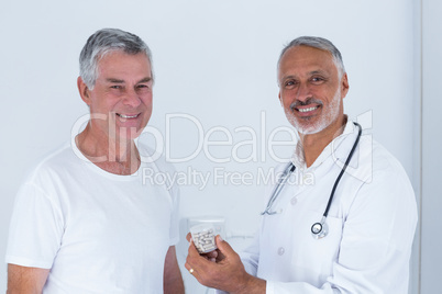 Portrait of male doctor giving pills to senior man