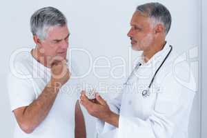 Male doctor advising senior man on medical prescriptions