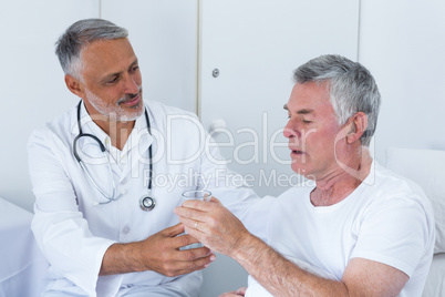 Male doctor and senior man interacting with each other