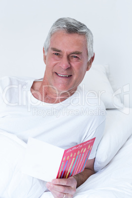 Senior man holding birthday greeting card