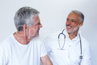 Male doctor and senior man interacting with each other