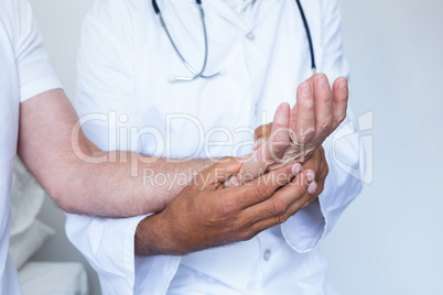 Male doctor giving palm acupressure treatment to the patient