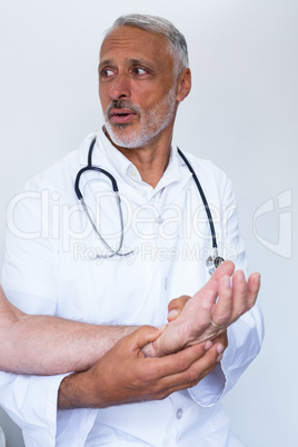 Male doctor giving palm acupressure treatment to the patient