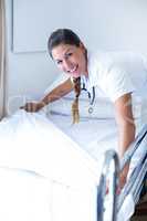 Portrait of smiling female doctor preparing the bed