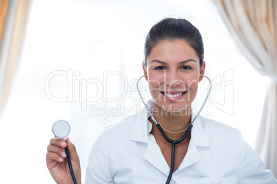 Portrait of female doctor showing stethoscope