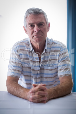 Portrait of confident senior man in living room