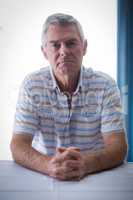 Portrait of confident senior man in living room