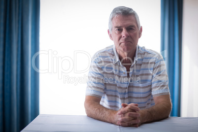 Portrait of confident senior man in living room