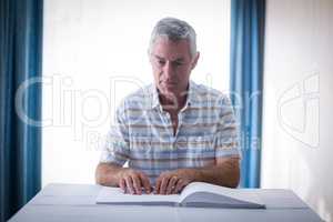 Blind man reading a braille book