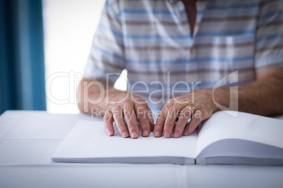 Blind man reading a braille book