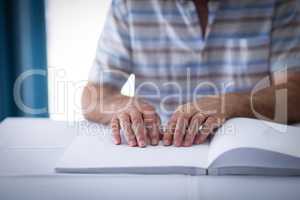 Blind man reading a braille book