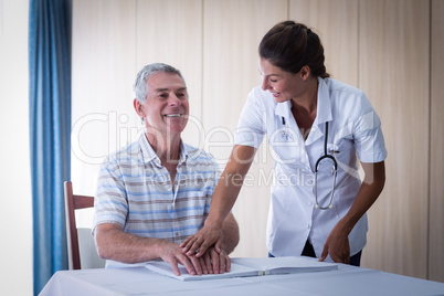 Female doctor helping patient in reading the braille book