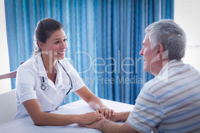 Smiling female doctor consoling senior man